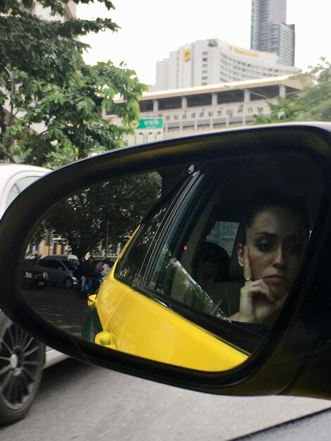 A tourist safely entering a licensed taxi in Rio de Janeiro, Brazil, with the driver visible and a taxi meter in the background.