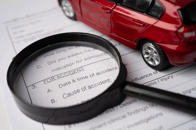 A person reviewing car rental insurance documents with a magnifying glass, emphasizing the details and careful consideration.