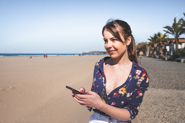 A female tourist using a smartphone app for real-time translation during a conversation with a local vendor at a bustling street market in Salvador, Bahia. The vendor is smiling and gesturing towards their goods, while the app displays the translated conversation.