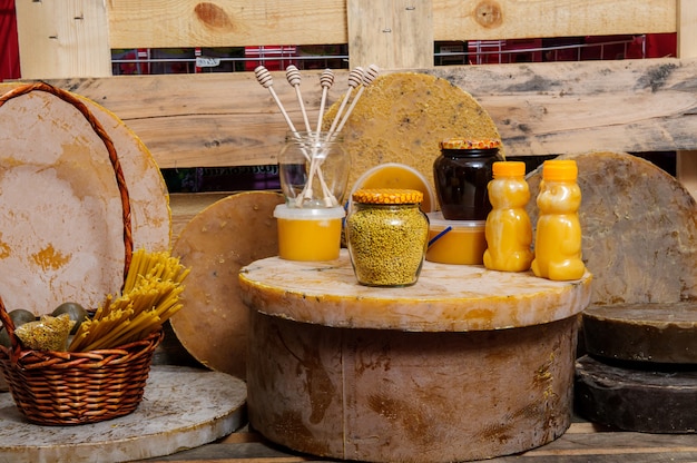 A rustic table laden with traditional Brazilian rural food, including cheese, bread, fruits, and homemade sweets. In the background, a smiling local woman is showcasing the products, highlighting the culinary experience and local hospitality.