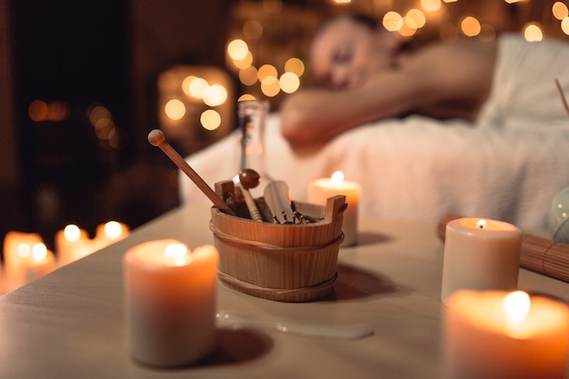 A peaceful spa setting with soft lighting, aromatherapy diffusers, and a person receiving a relaxing massage. The atmosphere is calm and inviting, promoting relaxation and stress relief.