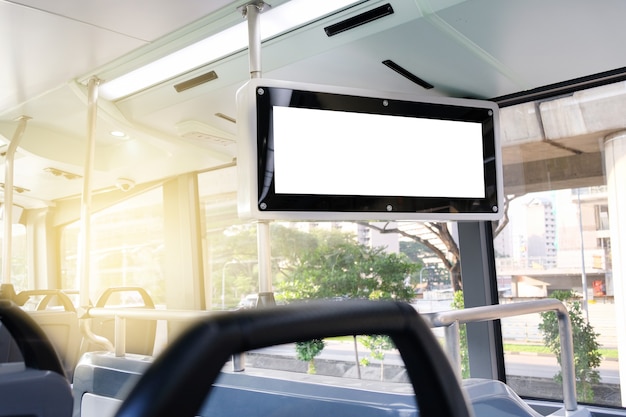 Interior of an electric bus showcasing modern design, comfortable seating, digital displays providing real-time information, and USB charging ports for passengers. The bus is clean, well-lit, and accessible, with ramps and designated spaces for wheelchairs. Passengers of diverse backgrounds are seen using their smartphones or relaxing during their commute.