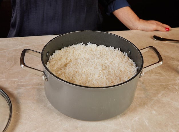 A pot of freshly cooked white rice, steaming and fluffy, with grains perfectly separated and glistening.