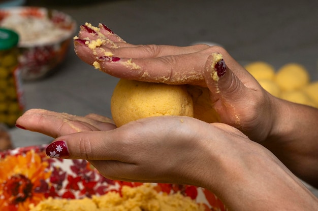 Close-up shot focusing on hands carefully sprinkling salt flakes over a vibrant and colorful acarajé being prepared in a traditional Bahian street food setting.