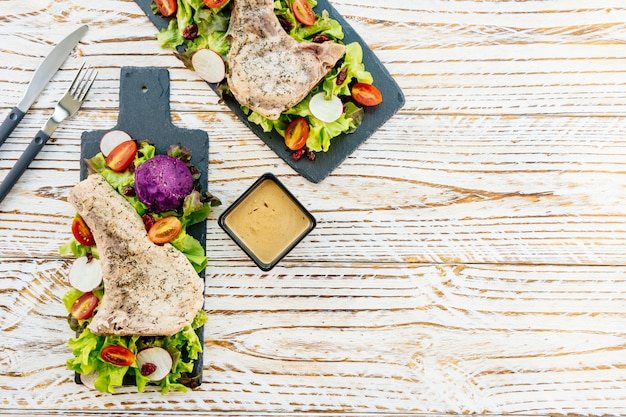 Top-down view of a chef preparing a chicken salad wrap with leftover roasted chicken, fresh vegetables, and a light sauce.