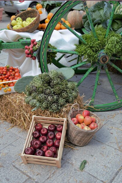 A vibrant display of fresh, seasonal fruits and vegetables at a local farmer's market. Focus on the variety of colors and textures, with vendors and shoppers interacting in the background. The lighting should be bright and natural, emphasizing the freshness of the produce.