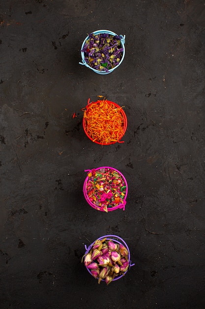 A top-down view of a colorful mix of Brazilian spices and herbs laid out on a rustic wooden surface, including turmeric powder, paprika, dried oregano, and cumin seeds, creating a visually appealing burst of vibrant colors and textures.