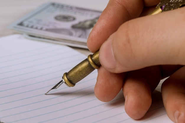 A close-up shot of a hand signing a loan agreement document, with a pen and a calculator nearby, symbolizing a financial transaction.