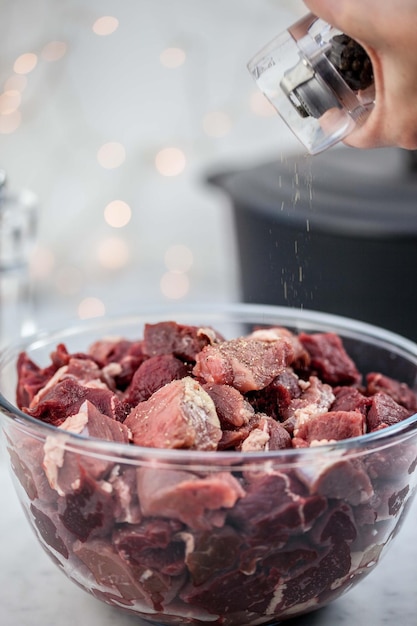 A close-up of various cuts of salted meats soaking in a large bowl of water, showing the process of desalting.